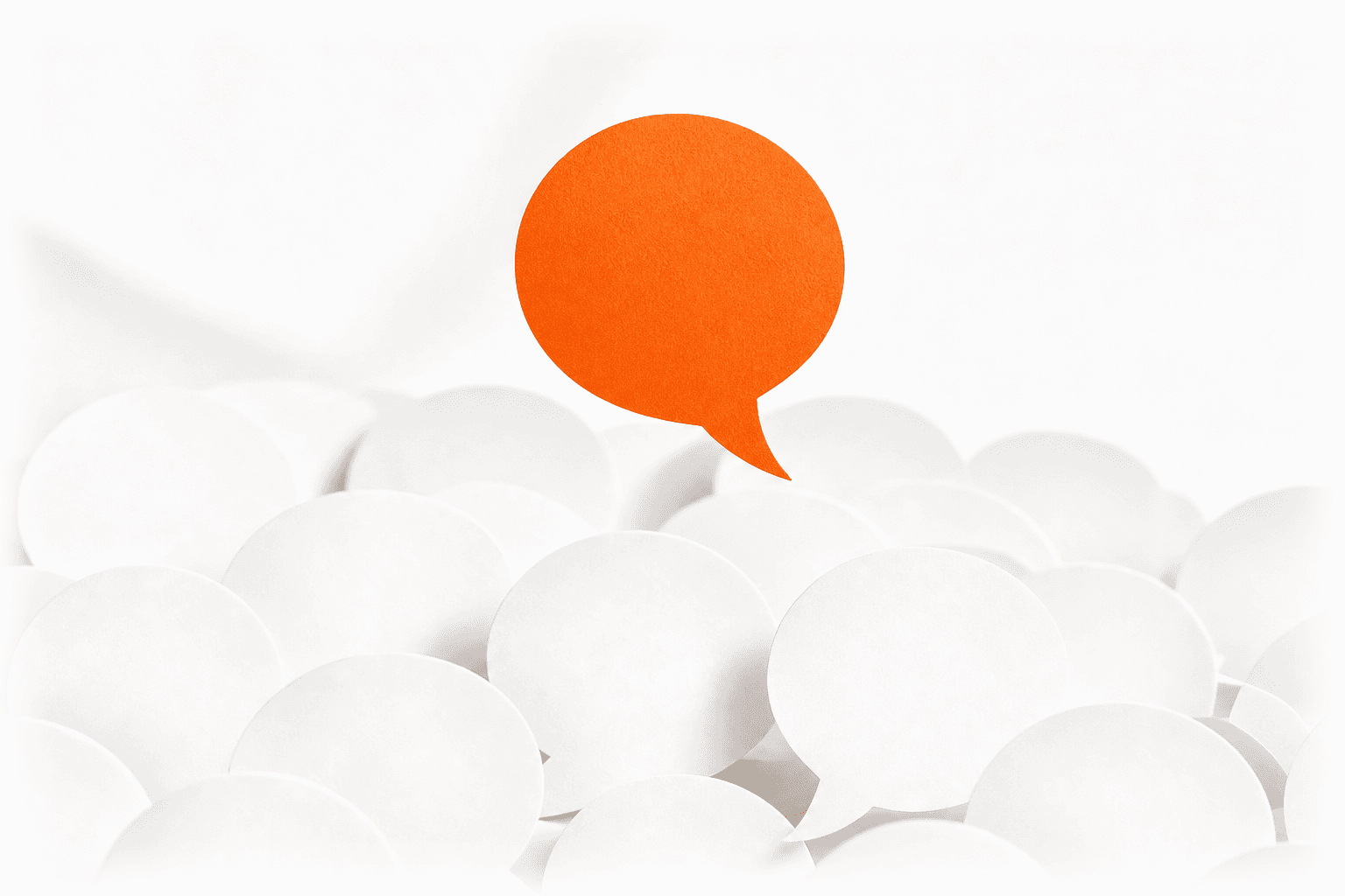 One orange paper speech bubble rising above a sea of plain white ones: the single answer named out of many.