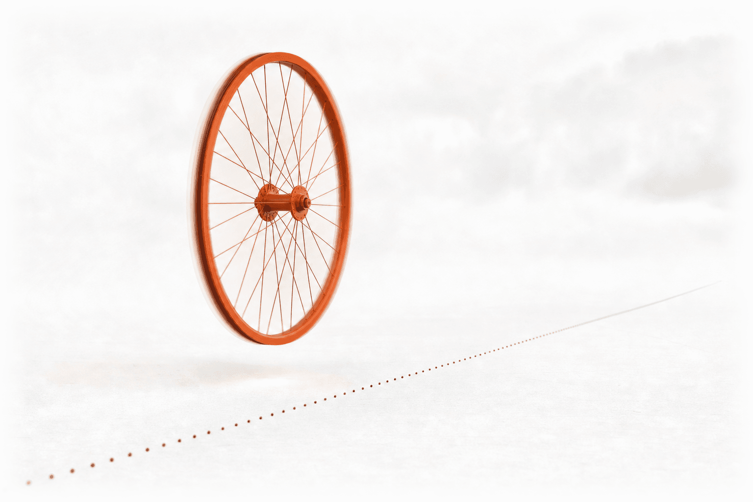A burnt-orange spoked wheel spinning in mid-air beside a dotted road line it never touches, a soft glow where its shadow should land: flat out, and going nowhere.