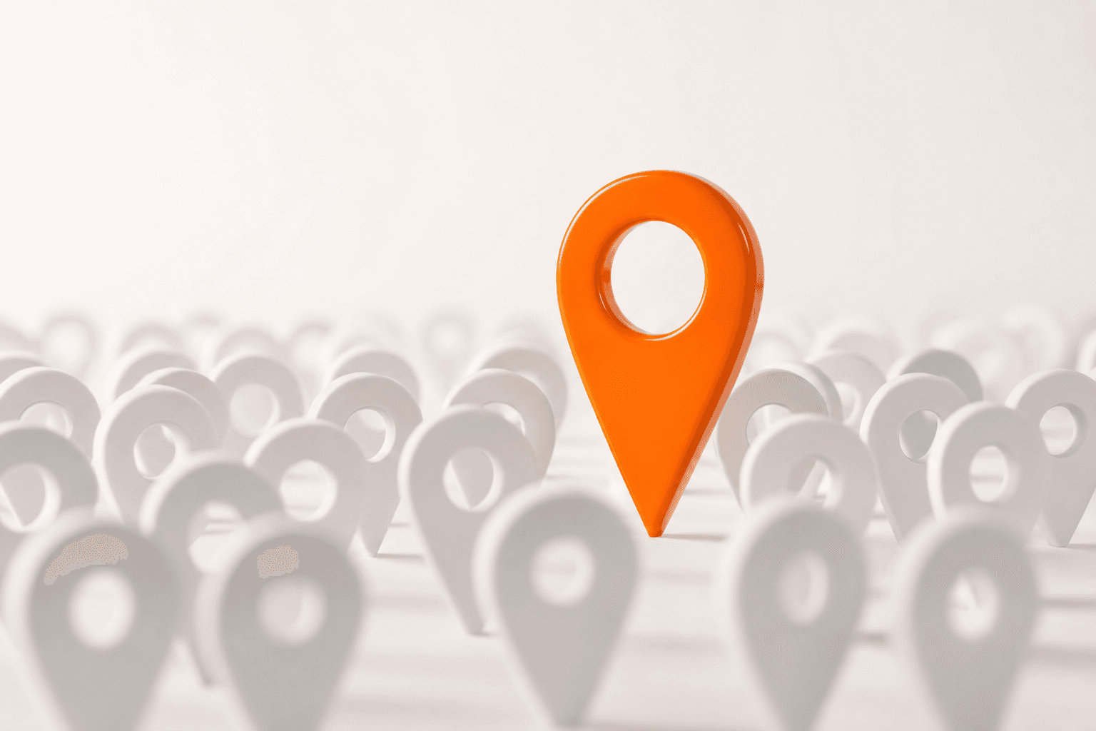One bright orange map pin standing tall above a crowd of plain white pins: the business chosen among many.